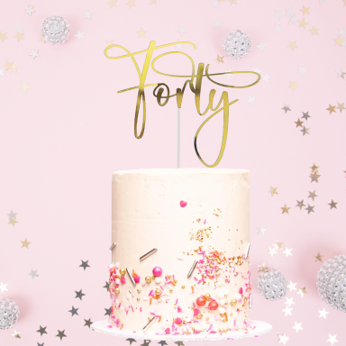 A pink-themed birthday cake with a gold "Forty" topper and colourful sprinkles.