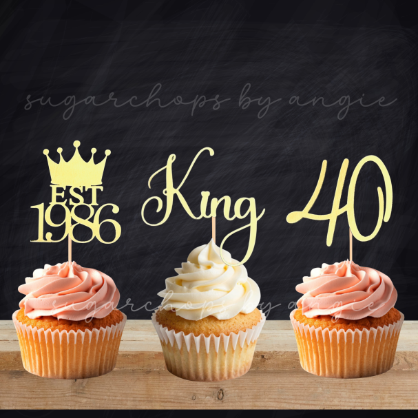 Three cupcakes topped with decorative cake toppers: "EST 1986," "King," and "40."