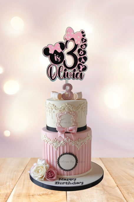 Two-tiered birthday cake decorated with pink and white, featuring a "3" topper and floral accents.