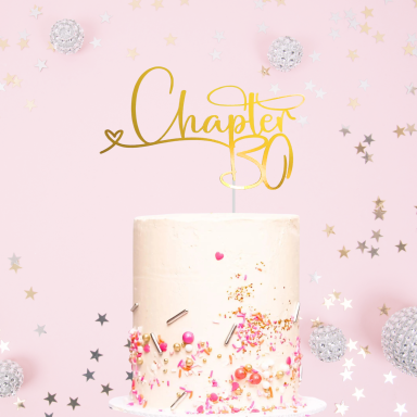 A decorated cake with "Chapter 30" topper and pink background, surrounded by confetti.